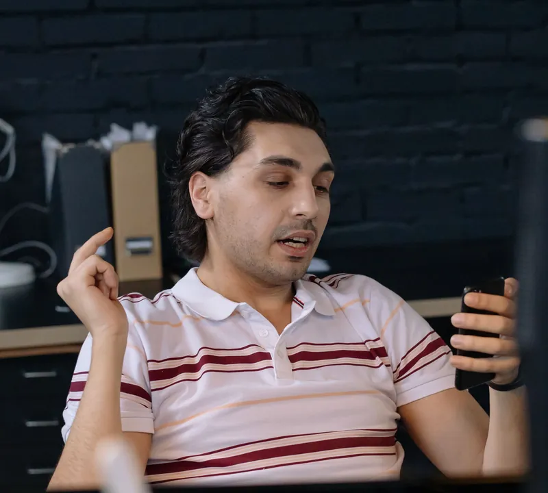 Assistant taking a phone call at his desk